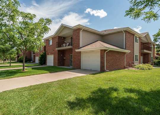 A large brick apartment building with a garage and a driveway.
