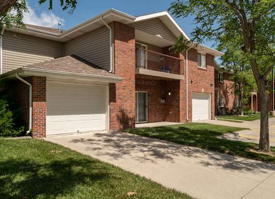 A two-story brick apartment building with a garage.