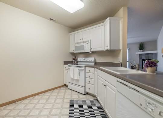 A kitchen with white cabinets and appliances.