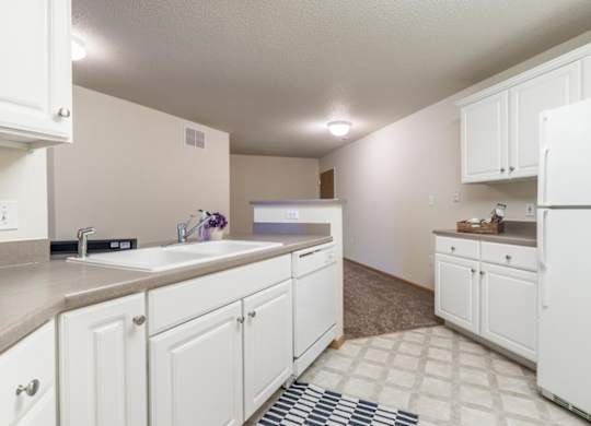A kitchen with white cabinets and appliances.