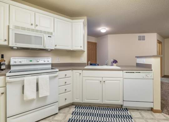 A kitchen with white appliances and cabinets.