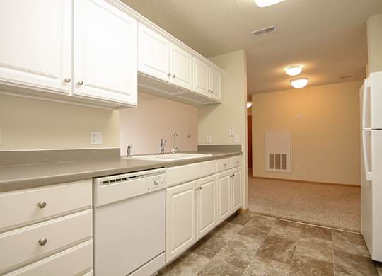 A kitchen with white cabinets and appliances.