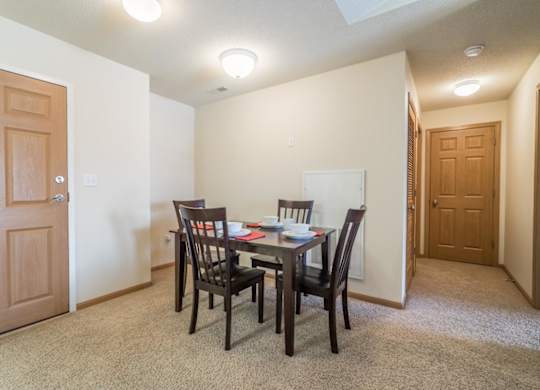 A dining room with a table set for two.