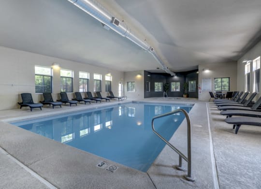 Pool with lounge chairs at Pinebrook Apartments!
