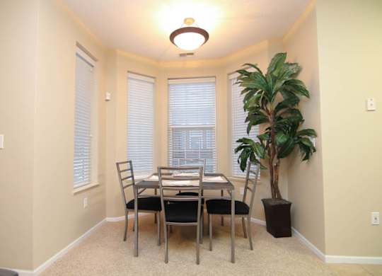 A dining room with a table and chairs.