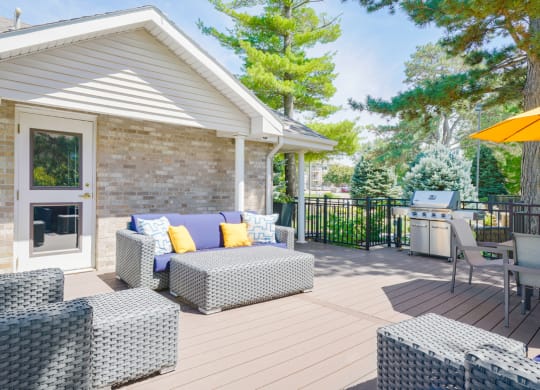 Sun deck with outdoor furniture for lounging and community grill in the back.