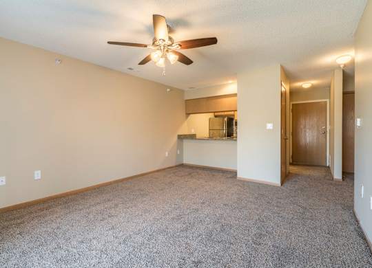 A room with a ceiling fan and carpeted floor.