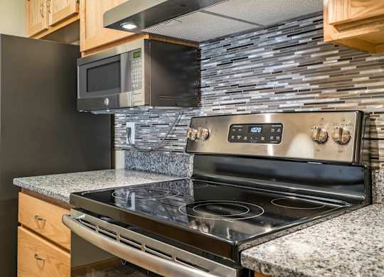 A modern kitchen with a black stove top oven and a black refrigerator.