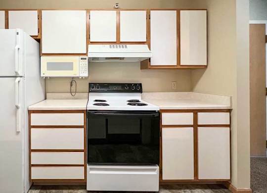 a kitchen with white white appliances and white and brown cabinets