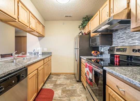A kitchen with granite countertops and stainless steel appliances.