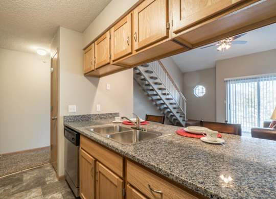 A kitchen with granite countertops and wooden cabinets.