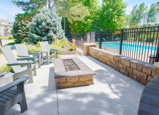 outdoor fire pit with seating outside of gated community pool