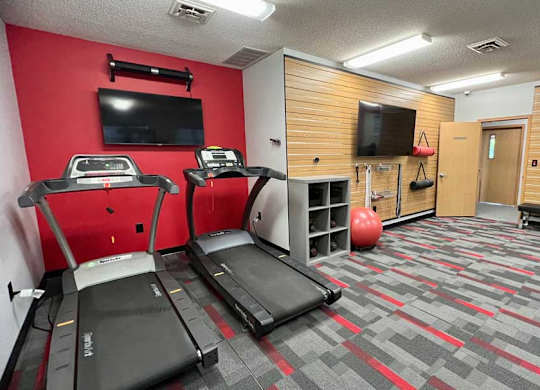 a 24-hour fitness center with treadmills, TVs, and yoga equipment.