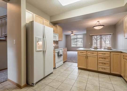 A kitchen with a refrigerator, oven, and cabinets.
