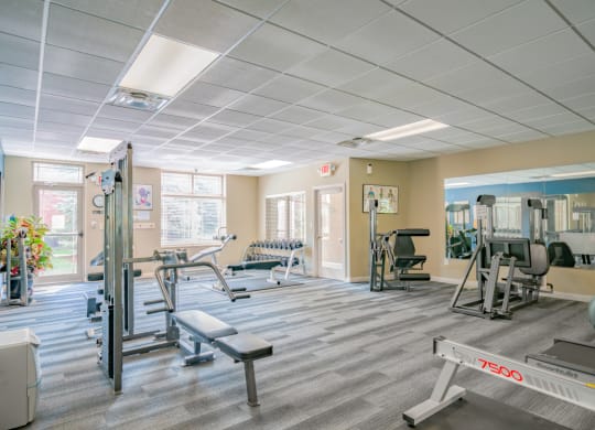 Spacious exercise room featuring cardio machines, free weights, and weightlifting machines at Southwind Villas in LaVista NE 68128