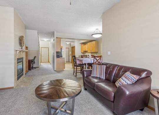 Open apartment kitchen with light wood cabinets, tile flooring, ample counter space, and adjacent dining area.