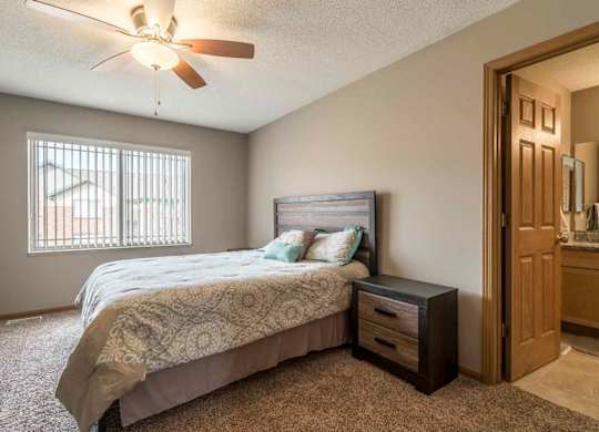 Master bedroom with attached bathroom and ceiling fan at Southwind Villas in southwest Omaha in La Vista, NE, 68128