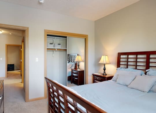 a bedroom with a bed and a mirrored closet door