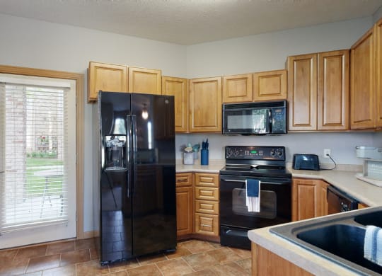 a kitchen with wood cabinets and black appliances