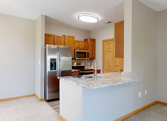 a kitchen with a granite counter top and a stainless steel refrigerator