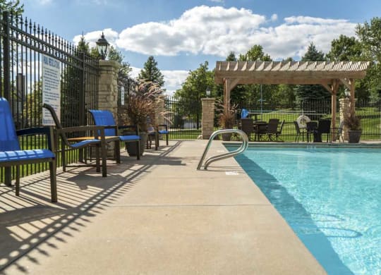Pergola with swimming pool and chairs at Stone Creek Villas townhomes in west Omaha NE 68116