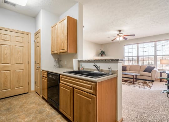 a view of a kitchen and a living room with a staircase