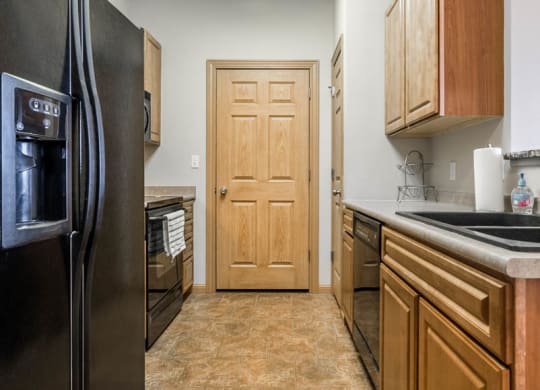 a kitchen with a refrigerator and a sink and a door