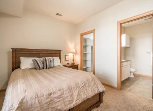 a bedroom with a bed and a bathroom with a toilet