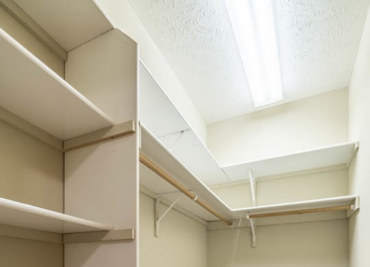 a walk in closet with empty shelves