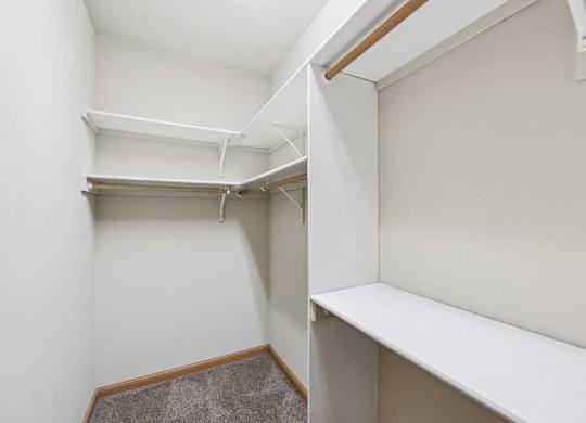 Walk-in closet with built-in shelving, hanging rods, and additional storage space.