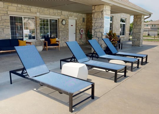 a row of chair loungers are lined up in front of the clubhouse building