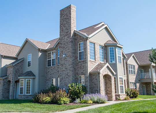 a villa building with brick and stone exterior on a sunny day