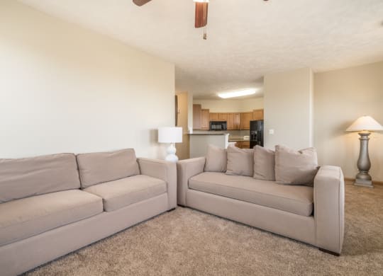 a living room with a couch and a chair and a kitchen