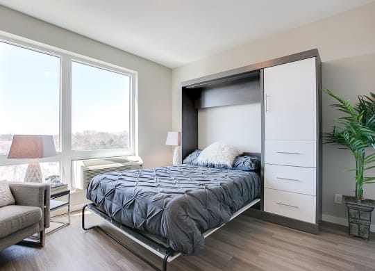 a bedroom with a bed and a large window