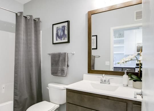 Quartz bathroom countertops with hardwood-style flooring at The Central apartments near downtown Minneapolis MN 55408