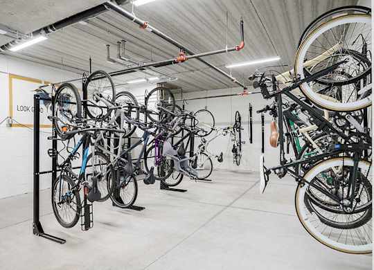 a bike locker room with multiple mounted spaces to hang bikes