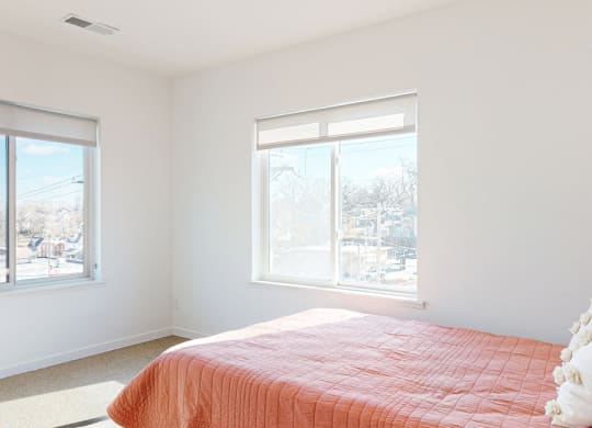 Furnished apartment bedroom with a large window on each wall