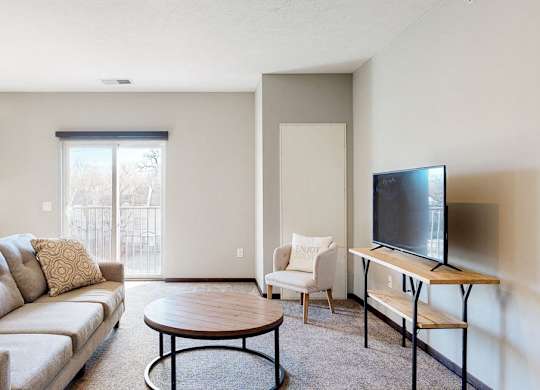 Furnished apartment living room with sofa, lounging chair, and coffee table