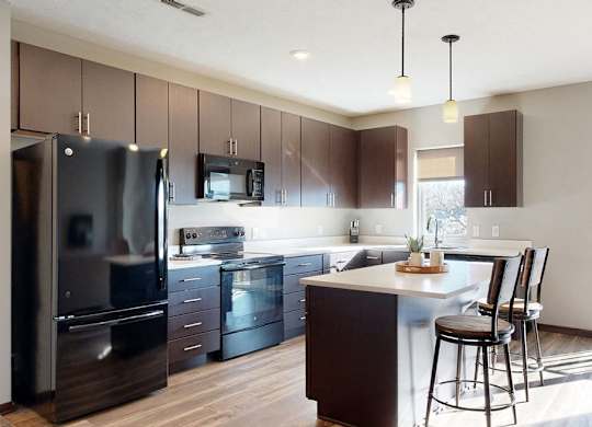 Furnished apartment kitchen with dark finish style and all black kitchen appliances