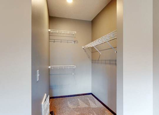 Walk in closet with plenty of shelving and hanging space in a furnished apartment at the conrad