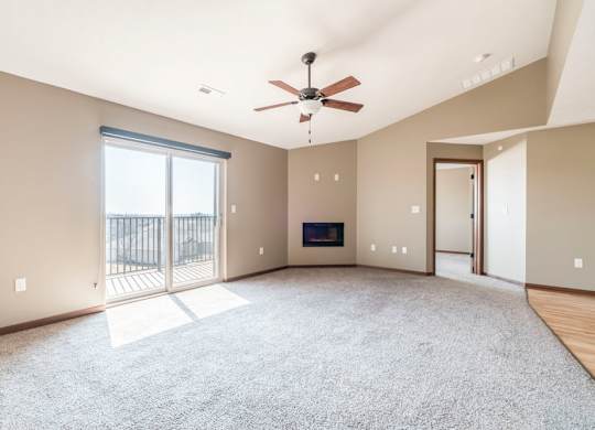 A spacious living room with a fireplace and sliding glass doors.