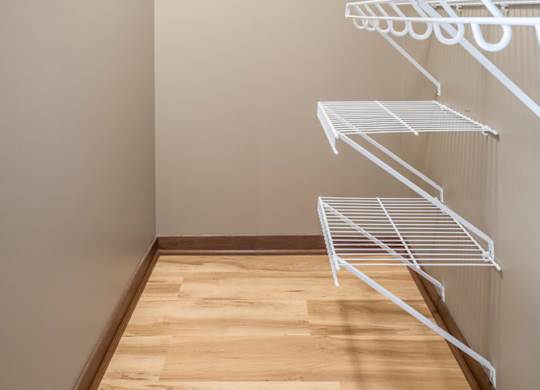 Empty white shelves in a room with wooden floor.