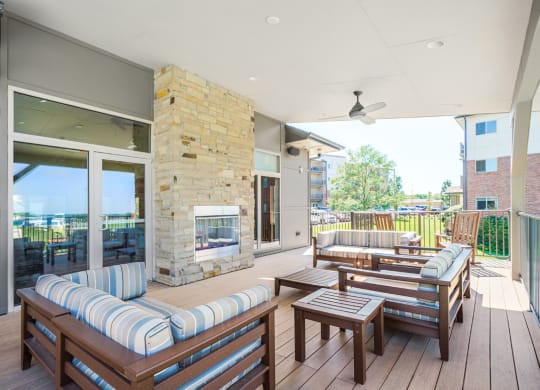 spacious patio with furniture surrounding outdoor stone fireplace