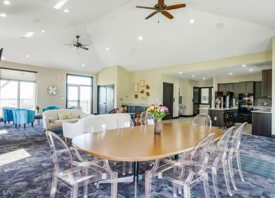 a dining area with a table and chairs and a kitchen in the background