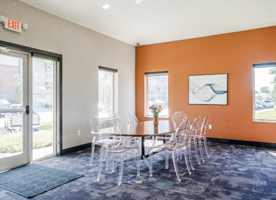 a table and chairs in front of a door in the flats at 84 clubhouse