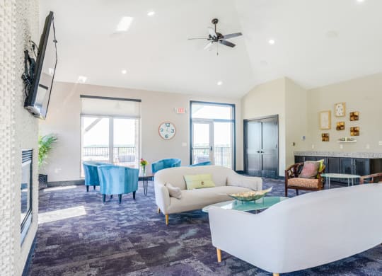 the flats at 84 clubhouse with white couches and blue chairs