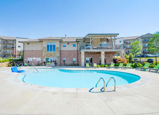 our resort style swimming pool with green lounge chairs