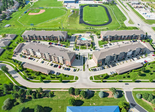 arial view of The Flats at 84 with green grass and a track in the background
