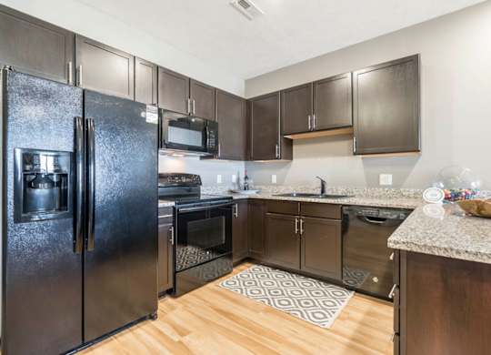 a large kitchen with stainless steel appliances and granite counter tops