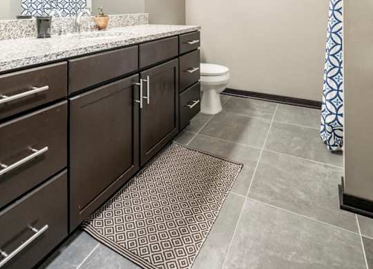 Bathroom with granite countertops and tile flooring at The Flats at 84 in southeast Lincoln NE 68516